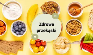 Zestawienie zdrowych przekąsek: jogurt, jagody, suszone morele, banan, batoniki musli, miód, orzechy, krakersy, pomidorki, hummus, papryka i seler.