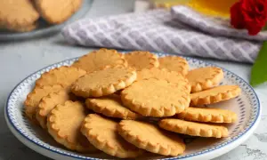 Stos pysznych, szybkich kruchych ciasteczek na talerzu z niebieskim wzorem. Idealne na popołudniową herbatę.
