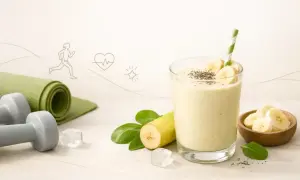 Idealny koktajl bananowy po treningu. Obok leżą hantle i mata do ćwiczeń.