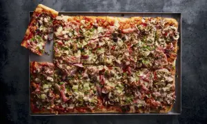 Domowa pizza na blachę z pieczarkami, szynką i oliwkami. Idealny przepis na świeże drożdże.