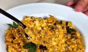 Pyszna pasta z makreli i twarogu, idealna na kanapki. Na czarnej łyżce widać kawałki ryby i sera, ozdobione natką pietruszki.