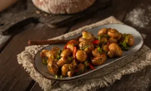 Pyszne pieczarki w marynacie do grzybów, podane z papryką i szczypiorkiem.