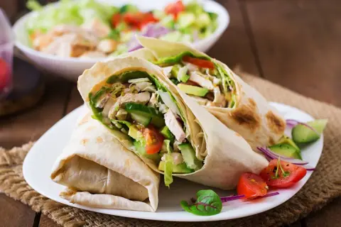 Dwa sycące wrapy z kurczakiem, awokado i warzywami. Idealne na szybki lunch, inspiracja do tortilla przepisy na nadzienie.