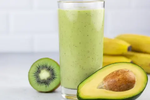 Zielony koktajl z awokado, kiwi i bananów w szklance.