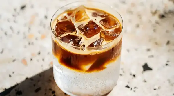 Orzeźwiająca kawa z tonikiem, z kostkami lodu i ciemnym espresso, idealna na upalny dzień.