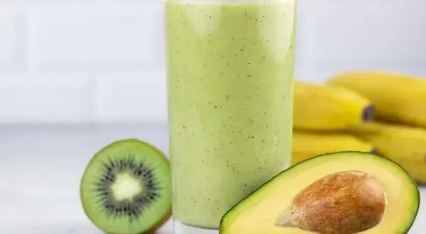 Zielony koktajl z awokado, kiwi i bananów w szklance.