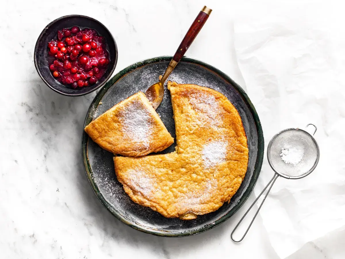 Słodki omlet posypany cukrem pudrem, podany z żurawiną. Idealny przepis na omlet na słodko.