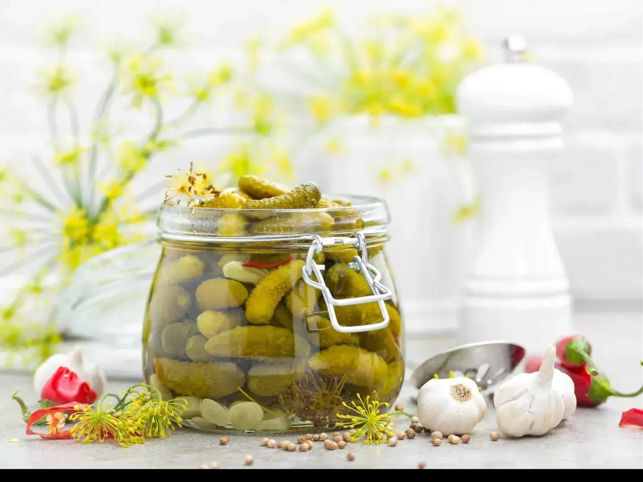 Słoik pełen przetworów z ogórków, z dodatkiem czosnku i chili. Nowości w spiżarni, gotowe do degustacji.