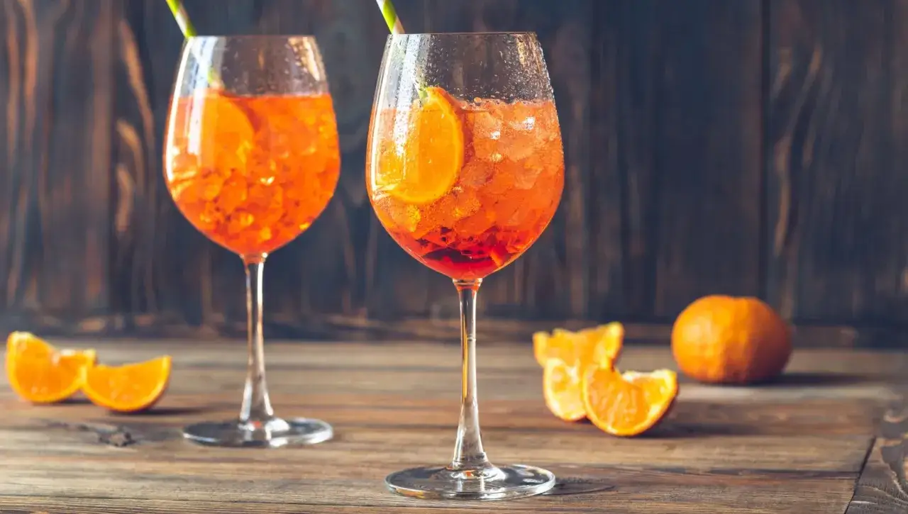 Dwa Aperol Spritz z pomarańczą i lodem. Idealne proporcje na letnie popołudnie.