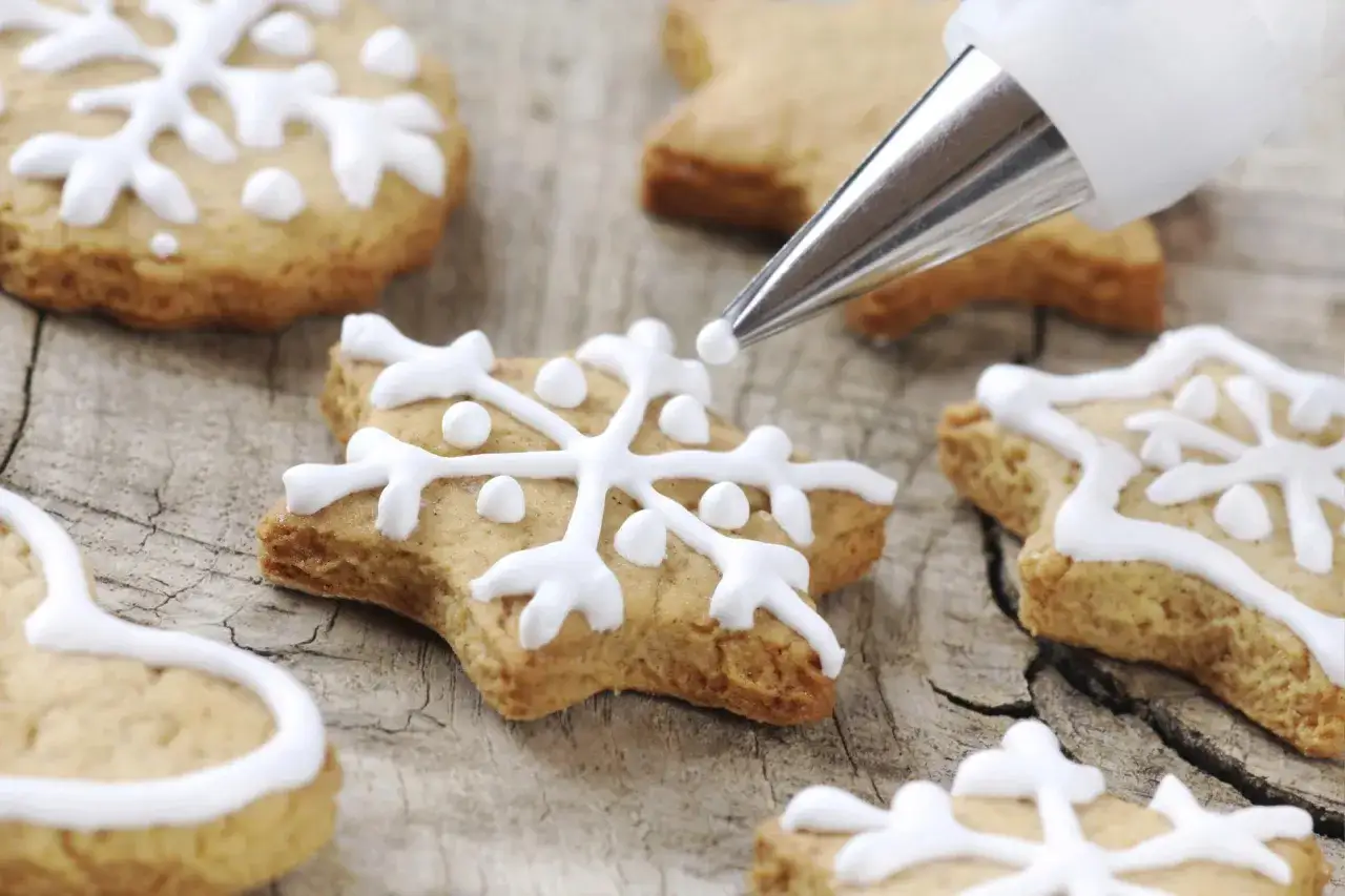 Dekorowanie pierników najprostszym lukrem do pierników. Gwiazdki i serca ozdobione białym lukrem.