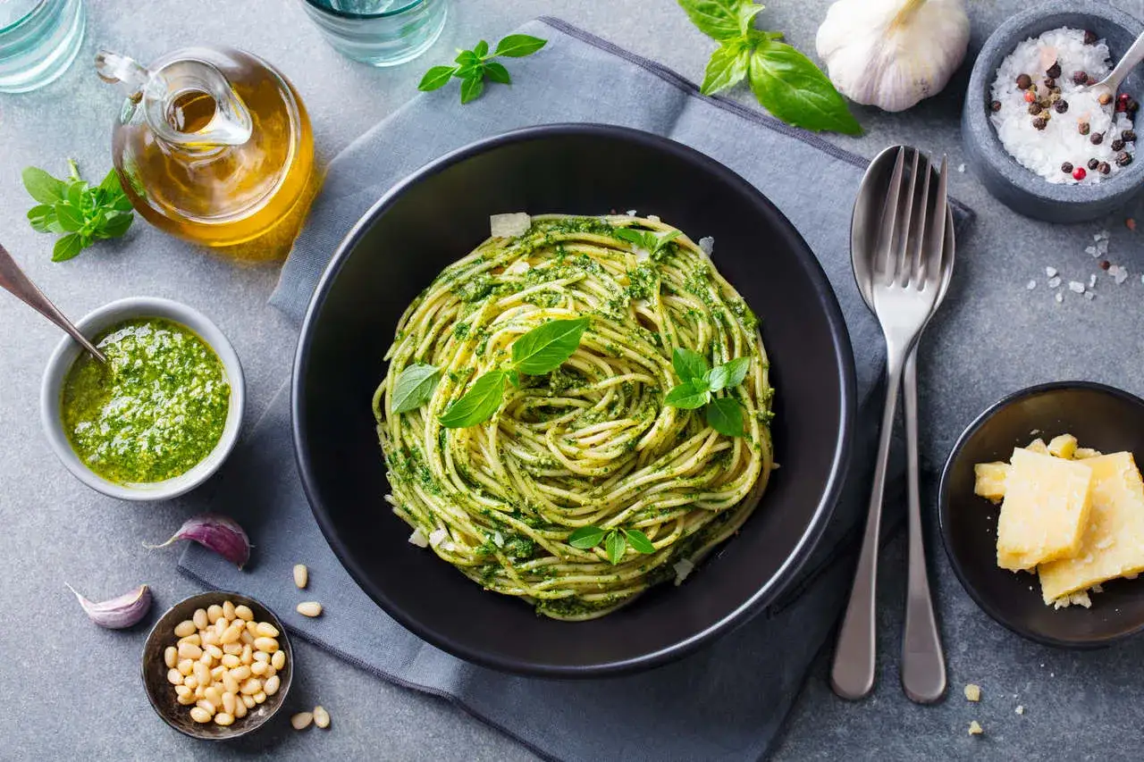 Pyszny pomysł na obiad bez mięsa: spaghetti z pesto, świeżą bazylią, orzeszkami pinii i parmezanem.