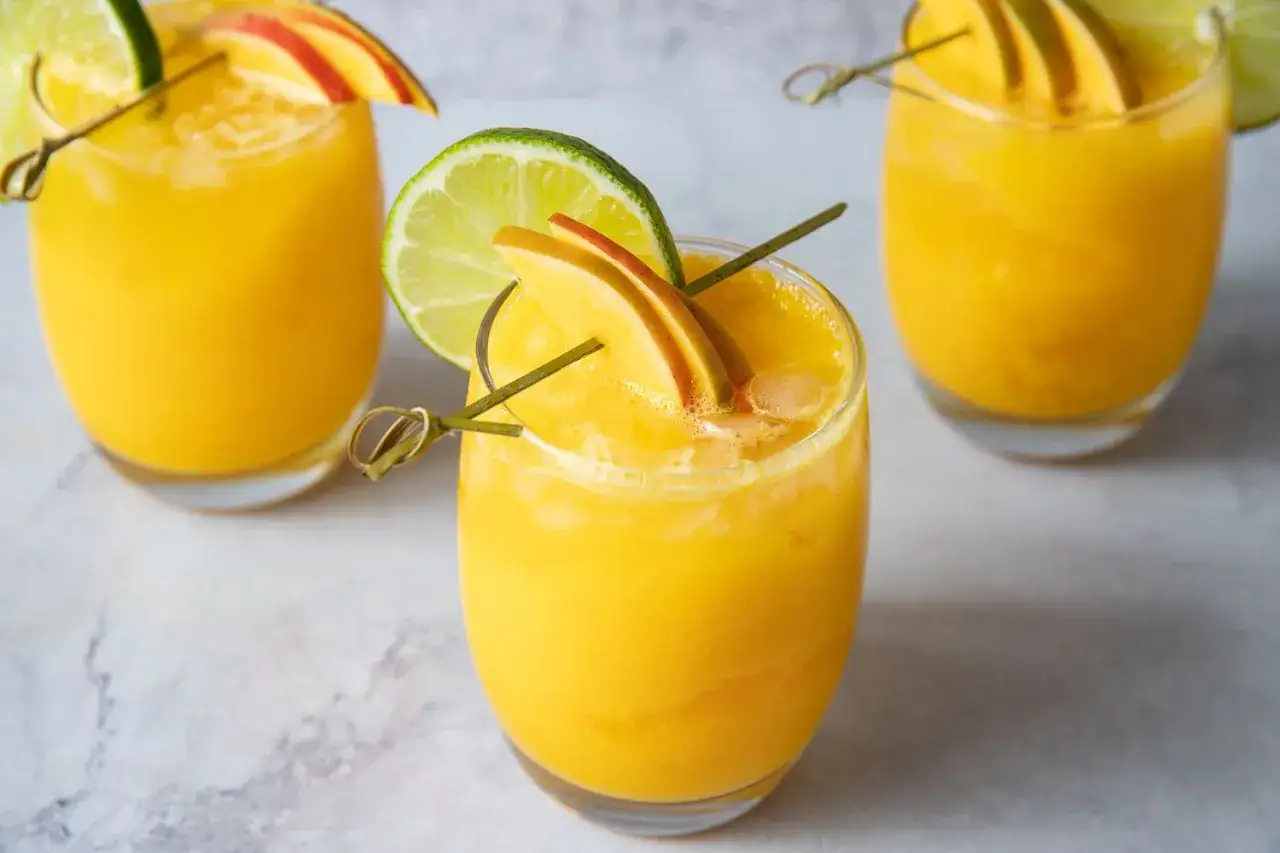 Orzeźwiający koktajl z mango, udekorowany plasterkiem limonki i owocu. Idealny na upalne dni.
