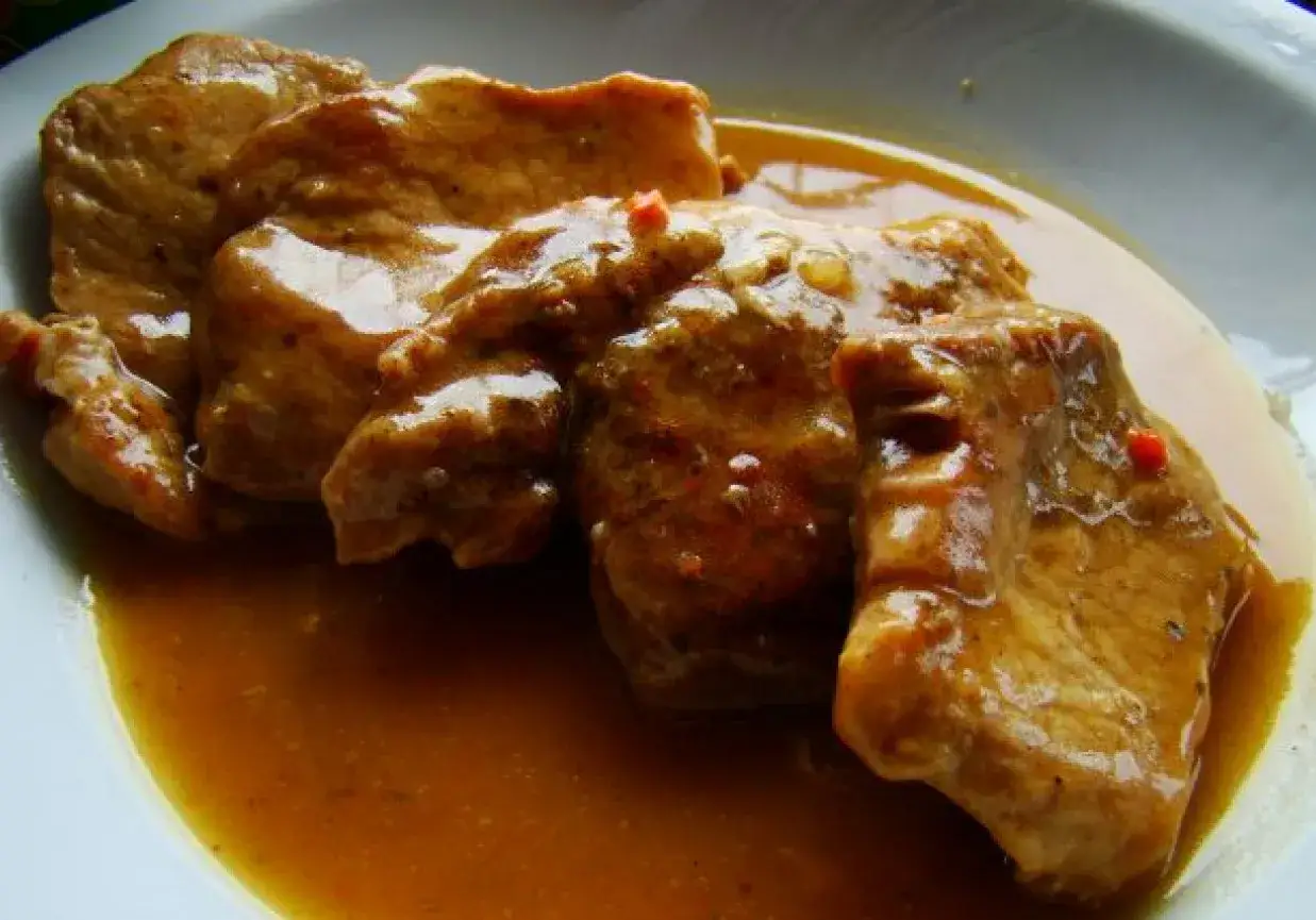 Kawałki wieprzowiny w aromatycznym sosie, który aż prosi się o dokładkę. Pyszny sos z szynki wieprzowej na talerzu.