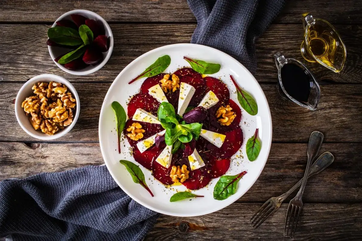 Carpaccio z buraka z serem feta, orzechami i ziołami, polane oliwą i octem balsamicznym. Idealny sos do carpaccio z buraka podkreśla smak dania.