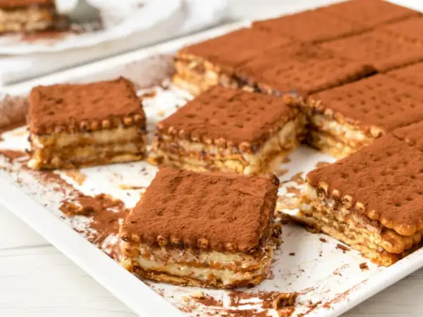 Pyszne, tanie ciasto bez pieczenia z herbatnikami, posypane kakao. Idealne na deser!