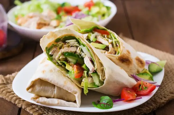 Dwa sycące wrapy z kurczakiem, awokado i warzywami. Idealne na szybki lunch, inspiracja do tortilla przepisy na nadzienie.