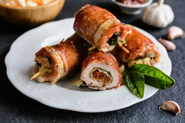 Roladki schabowe pieczone w naczyniu, zawinięte w boczek, z nadzieniem ze szpinaku i suszonych pomidorów.