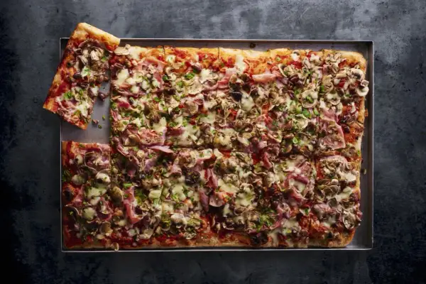 Domowa pizza na blachę z pieczarkami, szynką i oliwkami. Idealny przepis na świeże drożdże.